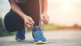 osoba wiążąca sznurówki w obuwiu sportowym