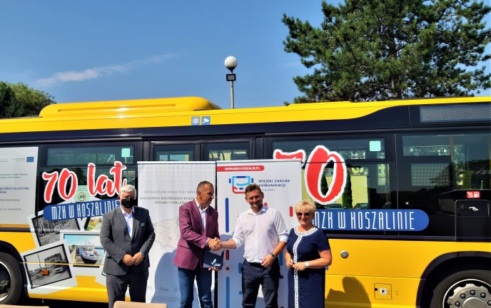 Przed autobusem MZK Andrzej Bacławski  - Prezes spółki MZK Koszalin podaje rękę Tomaszowi Sobieraj wicemarszałkowi województwa zachodniopomorskiego. Obok Prezesa Bacławskiego stoi Andrzej Kierzek wiceprezydent Miasta Koszalin natomiast obok wicemarszałka Tomasza Sobieraja stoi Aleksandra Ciesielska Członek Zarządu, Główny Księgowy 