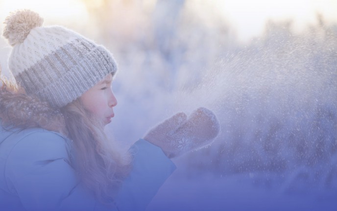 Dziewczynka w czapce bawiąca się śniegiem