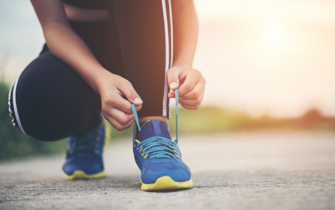 osoba wiążąca sznurówki w obuwiu sportowym