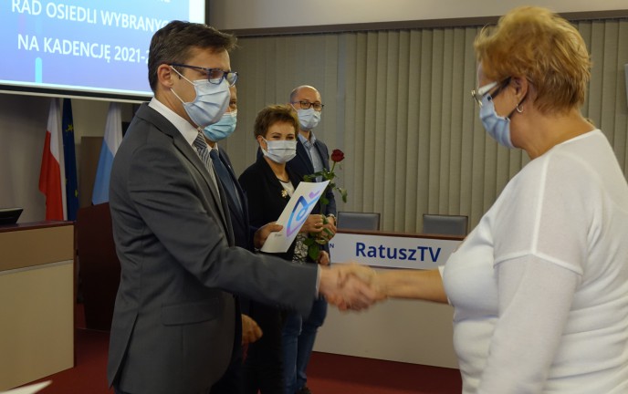 Na zdjęciu Sekretarz Miasta wręcza akt nadania członkini Rady Osiedla 