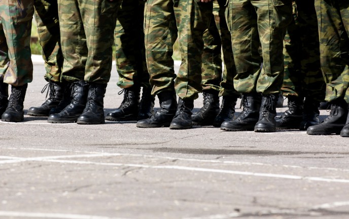 Na zdjęciu znajdują się stopy w wojskowym ubraniu oraz butach