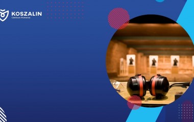 Na grafice znajdują się cele oraz słuchawki wygłuszające na strzelnicy.