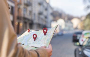 widok z boku jak ręce trzymają mapę papierową